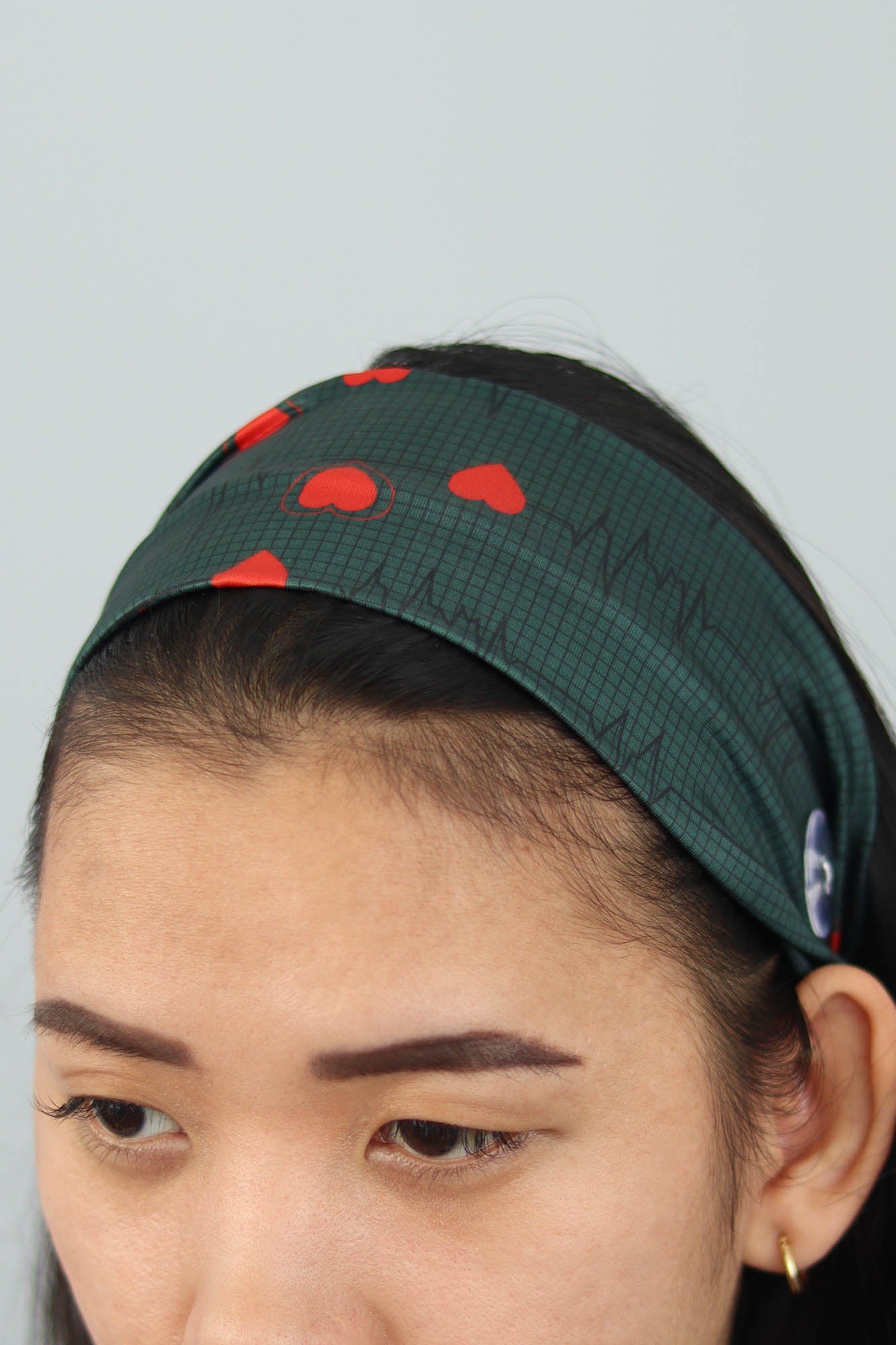 Beautiful Unisex Surgical hat with Cardiogram Heartbeat design on a green background. The oversized stylish plastic button on the side.