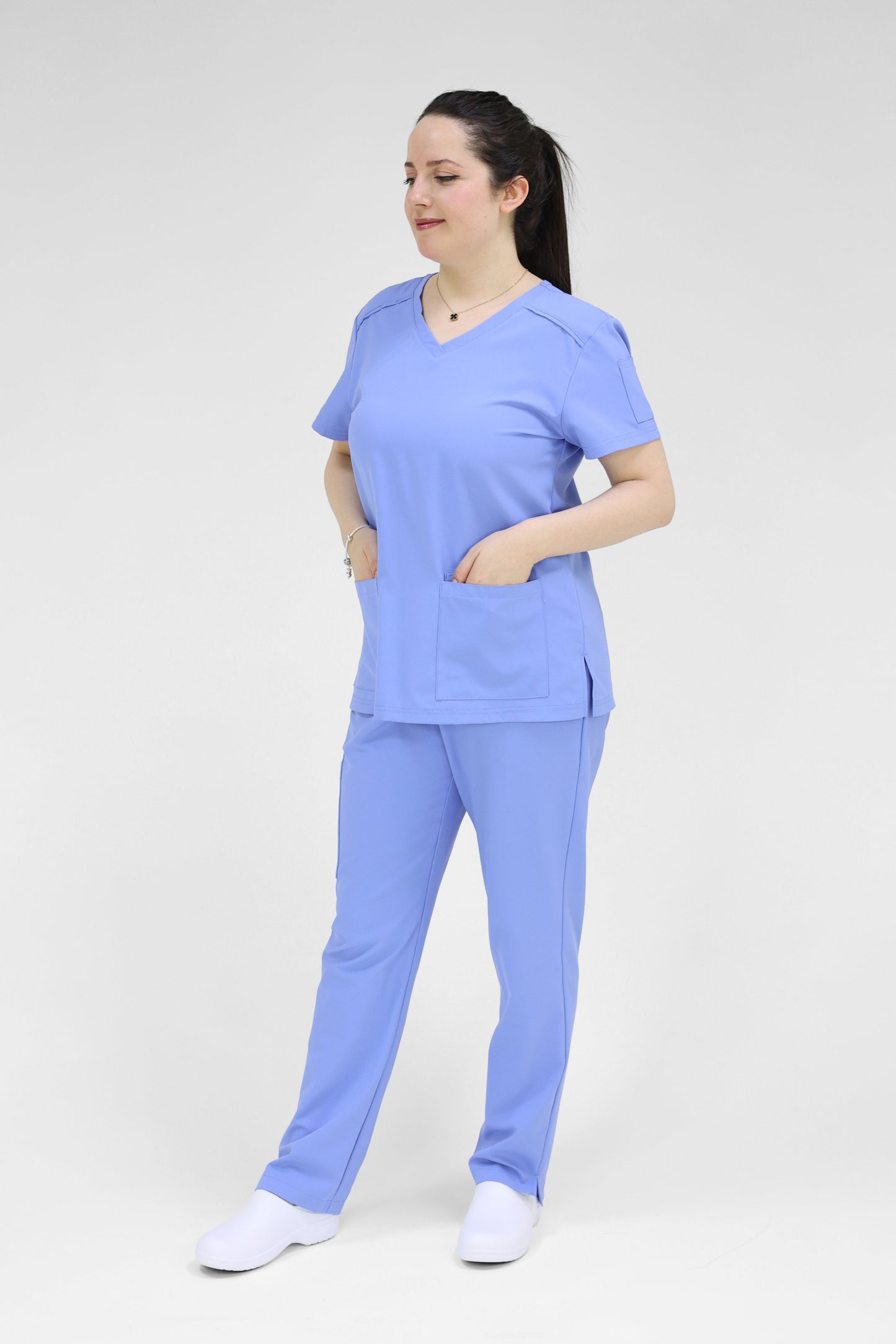 Person wearing a blue scrub set on a white background