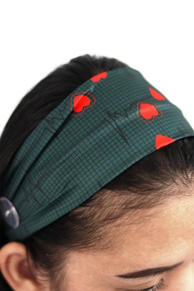 Beautiful Unisex Surgical hat with Cardiogram Heartbeat design on a green background. The oversized stylish plastic button on the side.